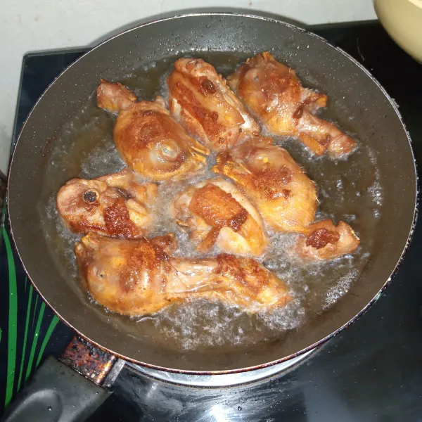 Panaskan minyak lalu masukkan ayam, goreng hingga garing dan cokelat kering. Tiriskan dan siap disajikan.