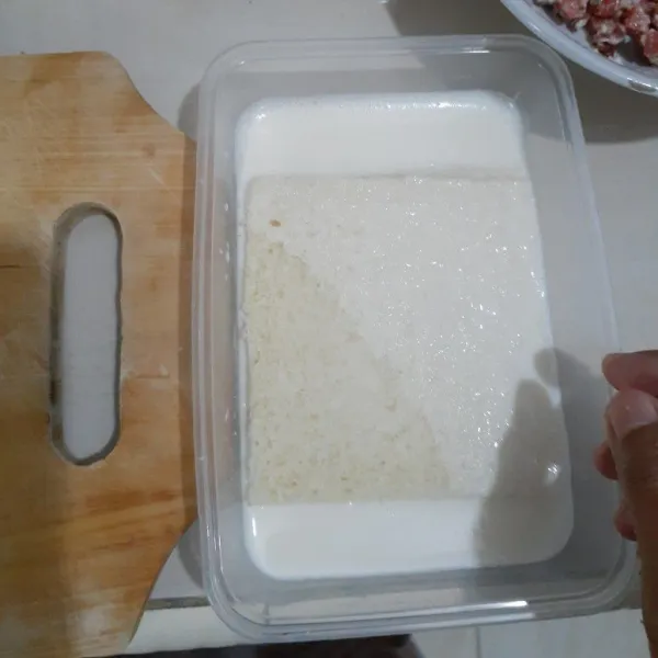 Siapkan roti tawar kupas dan celupkan ke dalam susu cair, lalu pipihkan