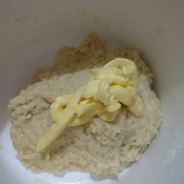 Kemudian tuangkan bahan biang perlahan, aduk dengan spatula sampai tercampur rata lalu masukkan margarin