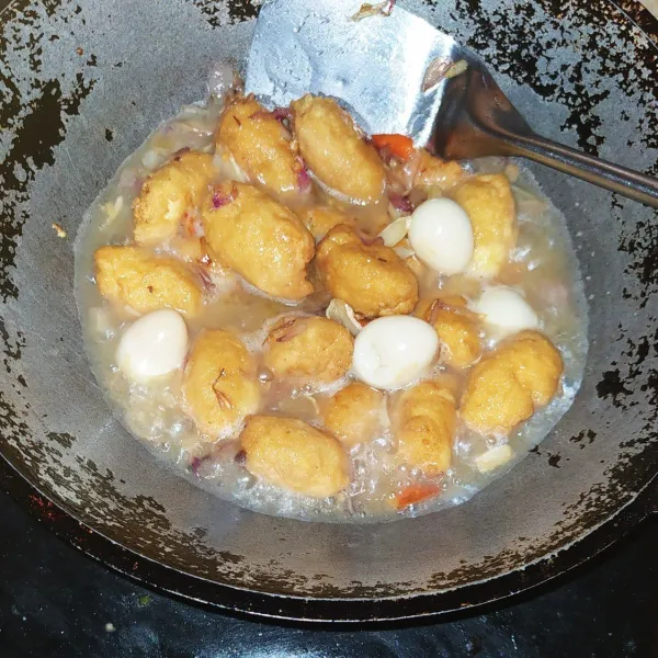 Panaskan mentega lalu masukkan bumbu iris masak sampai harum dan layu lalu masukkan air, nasi kepal dan telur