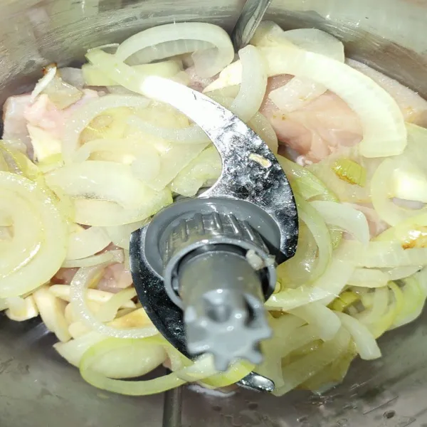 Campurkan daging ayam, bawang putih dan bawang bombay, lalu giling hingga lembut