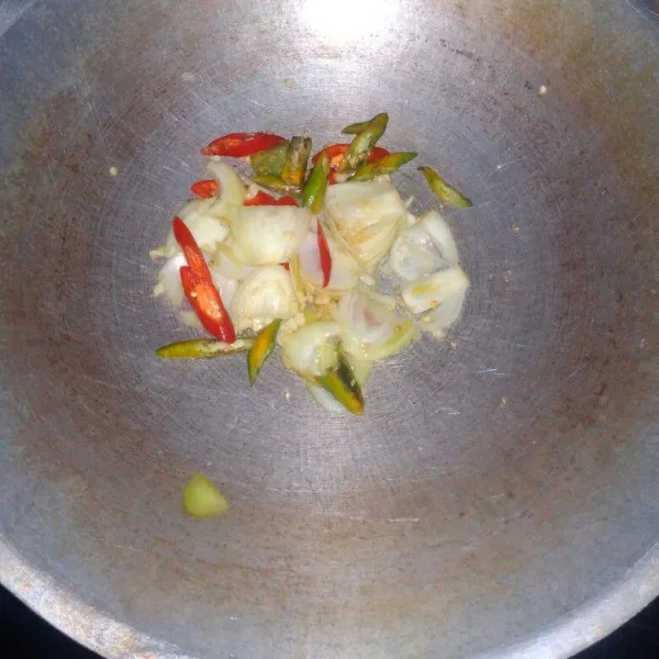 Tumis bawang putih dan bawang bombay sampai harum, masukkan cabai merah dan cabai hijau, aduk rata.