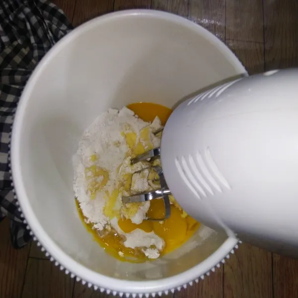 Mixer margarin, telur dan gula hingga lembut mengembang. Matikan mixer.