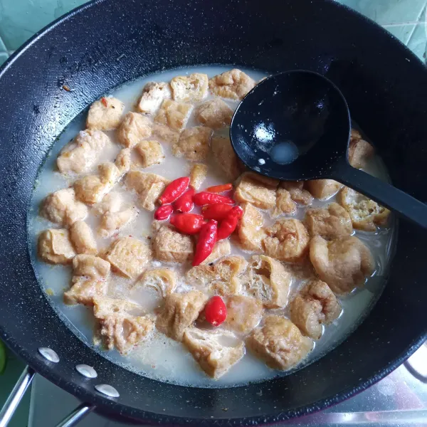 Tuang air, beri santan bubuk dan masukkan cabai rawit. Tunggu mendidih sambil diaduk-aduk sesekali.