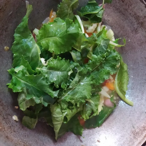 Masukkan daun kale dan saus tiram, aduk rata