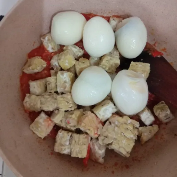 Masukkan tempe kukus dan telur rebus, aduk rata.