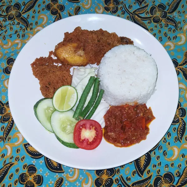 Sajikan ayam selimut dengan sambal dan pelengkap lain.