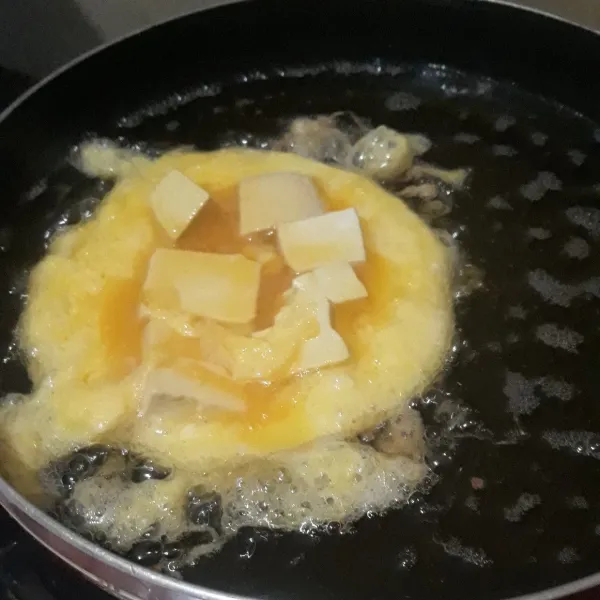 Telur yang sudah diberi garam secukupnya dicampur potongan tahu lalu digoreng dalam minyak panas sampai matang (saya 4 kali goreng). Angkat dan sisihkan.