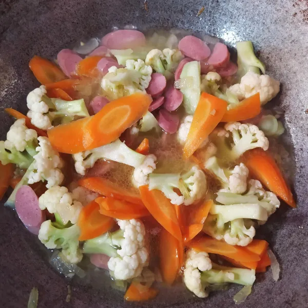 Beri air dan masukkan garam, gula dan lada. Aduk rata, masak sampai sayuran agak empuk