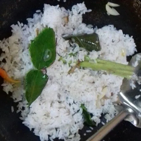 Masukkan nasi, aduk rata hingga nasi tidak menggumpal dan air meresap.