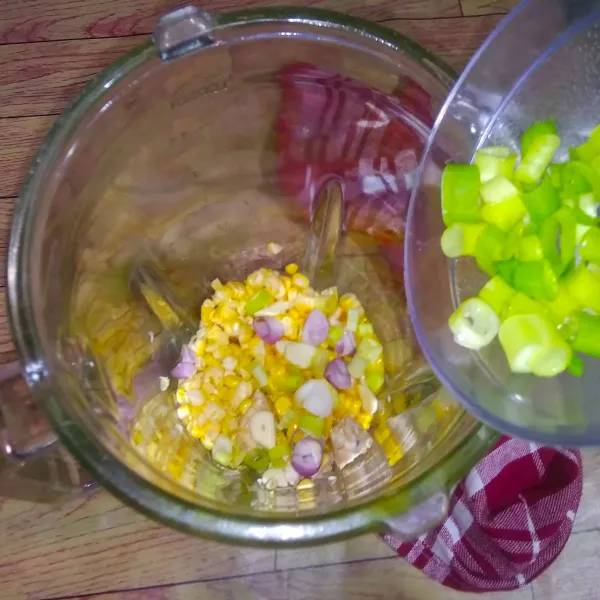 Masukkan jagung, tempe, bawang putih, bawang merah dan daun bawang dalam blender. Proses hingga halus.