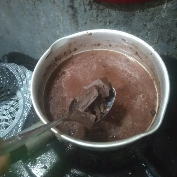 Aduk pelan-pelan hingga agak panas lalu masukkan coklat cincang. Aduk rata hingga coklat mencair.