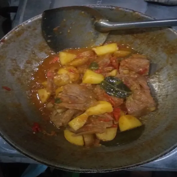 Masukkan kentang dan bumbu pelengkap, aduk dan masak sampai air menyusut, koreksi rasa. Angkat dan sajikan.