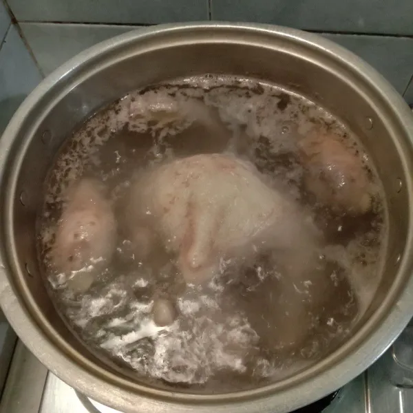 Siapkan panci dan tuangkan air sekitar 1/2 panci. Didihkan. Masukkan ayam dan ceker. Buang air rebusan pertama. Ulangi hal yang sama. Sisihkan air kaldu dari rebusan kedua. Angkat ayam, goreng sesaat dan suwir-suwir.