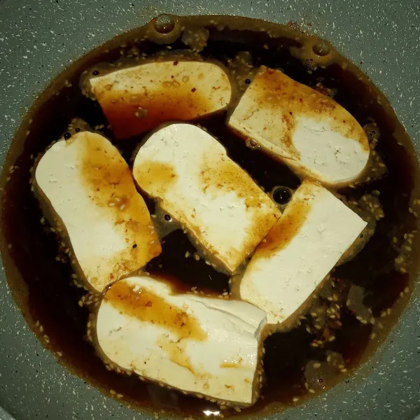 Tuang larutan dashi dan campuran kecap kepanci anti lengket, masak sampai mendidih. Masukkan tahu tata rapi.