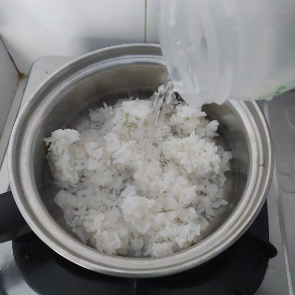 Masukkan nasi kedalam panci, tambahkan air. Masak sambil sesekali diaduk.