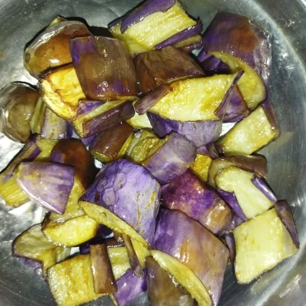 Cuci terong ungu, potong-potong, kemudian langsung goreng hingga agak kecoklatan.