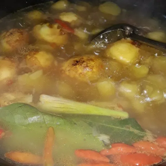 Selanjutnya masukkan kentang, sereh dan daun salam. Masak sampai kentang empuk lalu masukkan telur.