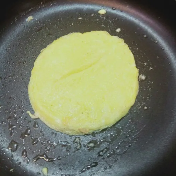 Oles teflon dengan minyak tipis, goreng telur lalu bentuk oval.