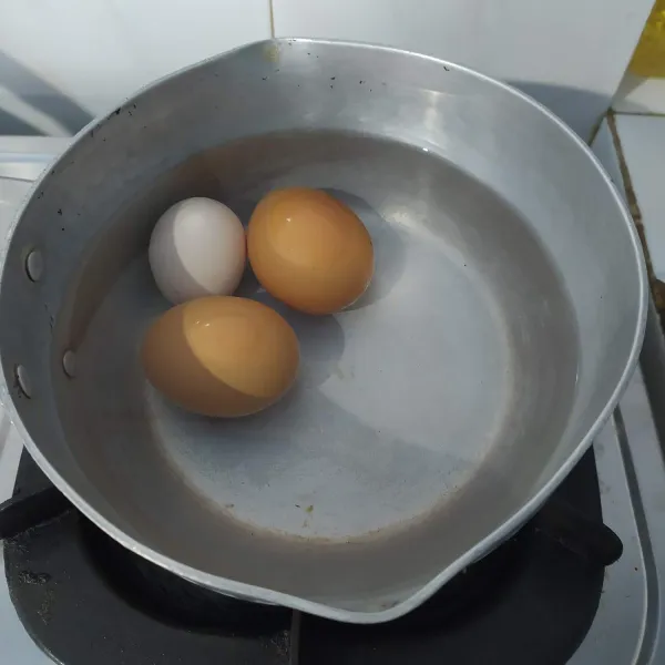 Didihkan air kemudian rebus telur ayam hingga matang (10 menit setelah air mendidih). Kemudian kupas kulitnya, sisihkan.