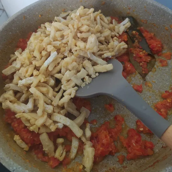 Masukkan tahu, aduk rata. Tambahkan sedikit air dan kecap manis. Aduk rata.
