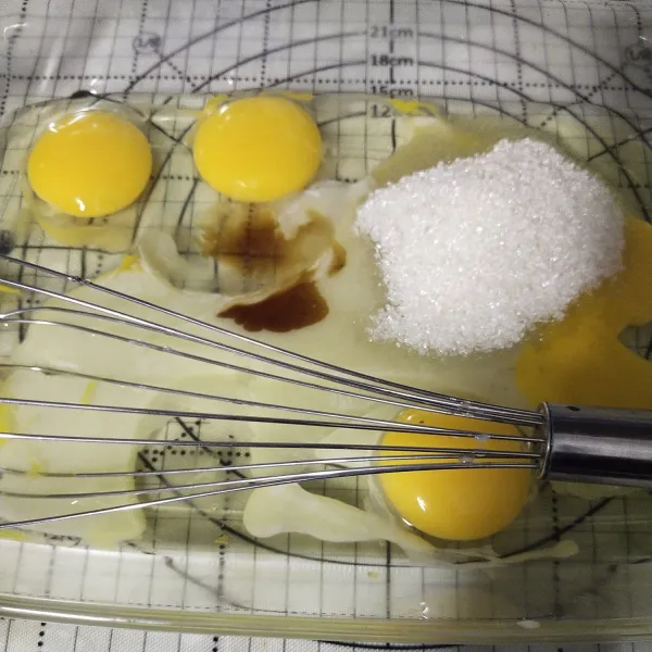 Pecahkan 4 buah telur kemudian beri gula pasir dan vanili, kocok sampai rata.
