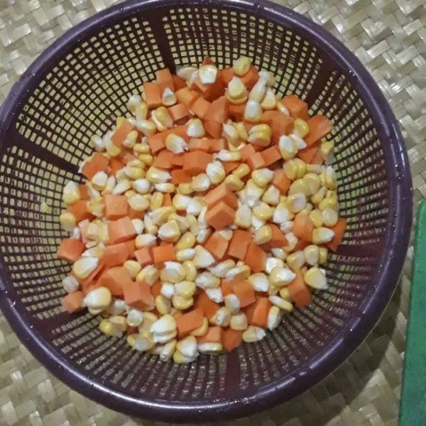 Potong dadu wortel dan pipil jagung, lalu cuci bersih dan tiriskan.