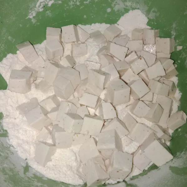Siapkan tepung terigu dan maizena masukkan tahu dan aduk hingga tahu tertutup tepung.