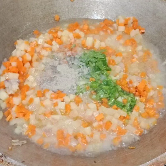 Panaskan sedikit minyak goreng dan tumis bumbu halus hingga harum. Masukkan kentang dan wortel, aduk rata. Beri air, irisan daun seledri, garam, kaldu bubuk dan merica bubuk. Masak hingga sayuran empuk.