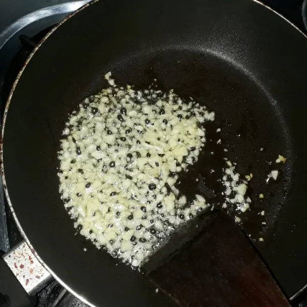 Panaskan minyak goreng, lalu tumis bawang putih hingga harum.