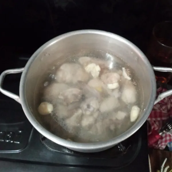 Didihkan lagi air baru, rebus kembali ayam sampai empuk bersama jahe dan bawang putih.