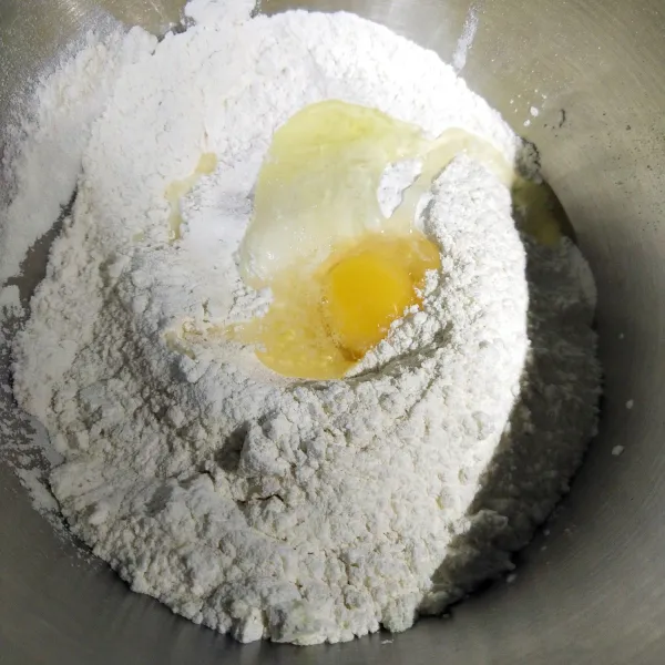 Masukkan tepung terigu, ragi, gula pasir, telur, dan susu bubuk. Aduk dengan mixer sampai setengah kalis.
