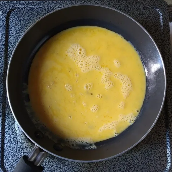 Panaskan teflon, beri sedikit margarin, tuang adonan telur, masak dengan api kecil.