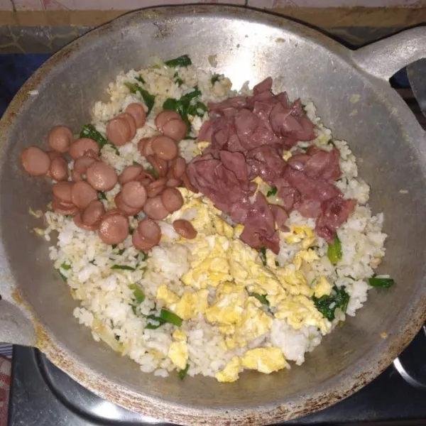 Tambahkan nasi, smoked beef, sosis dan telur. Beri garam, penyedap jamur, lada dan saus tiram.