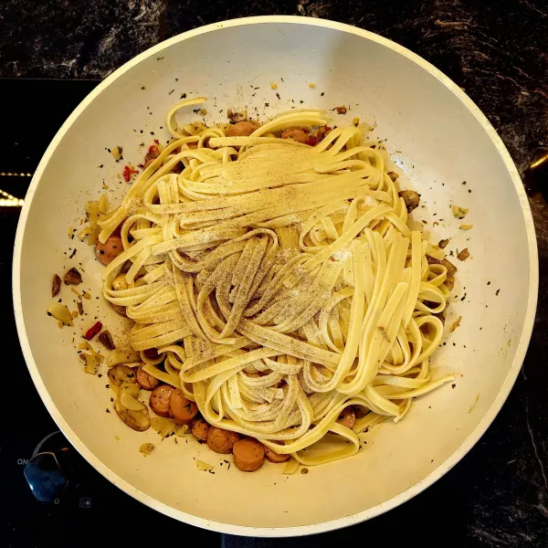 Masukkan spaghetti/fettuccine. Lalu tambahkan garam dan lada. Aduk semuanya sampai terlihat agak tercampur (tidak usah terlalu tercampur).