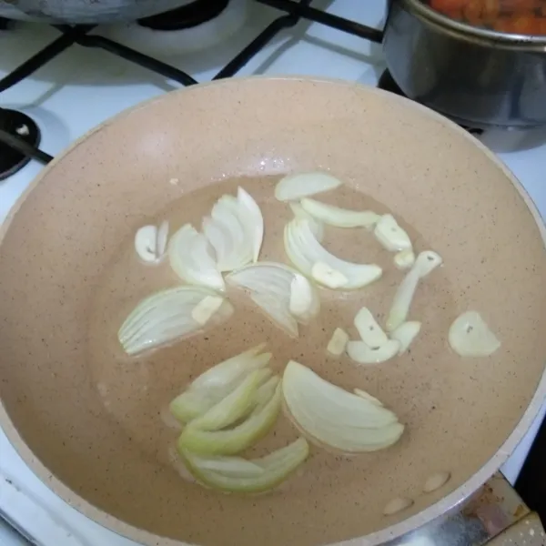 Tumis irisan bawang putih dan bawang bombay hingga harum.