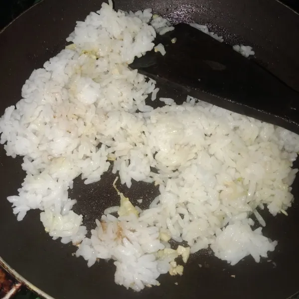 Masukkan nasi dan tambahkan garam, aduk hingga rata.