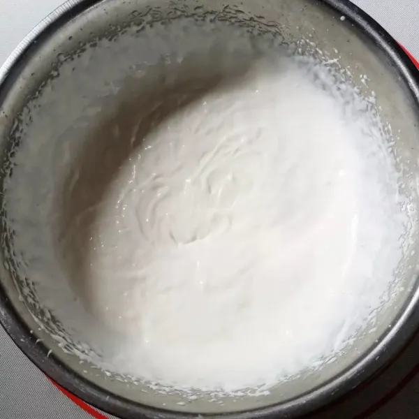 Kocok whipped cream cair bersama gula halus menggunakan whisk tidak perlu sampai kaku.