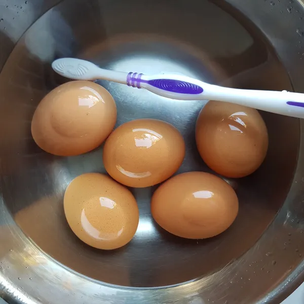 Sikat telur hingga bersih dari kotoran dan bilas. Sisihkan.