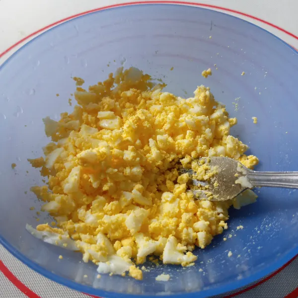 Hancurkan juga telur rebus menggunakan garpu.