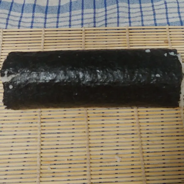 Gulung dan tekan hingga padat kemudian iris dengan pisau tajam dan kimbap siap disajikan dengan pelengkap kecap asin.