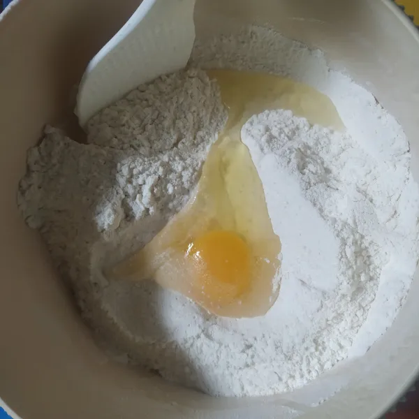 Kemudian siapkan adonan dengan campurkan tepung terigu, susu bubuk, gula pasir, dan telur. Aduk rata.