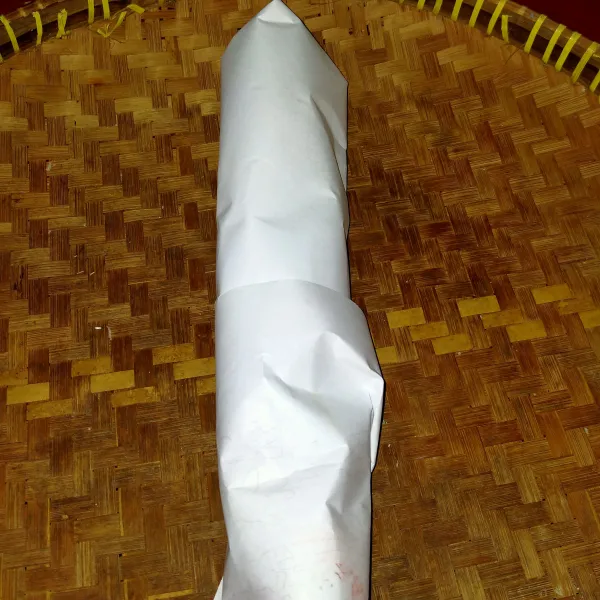 Bungkus daun seledri dengan kertas hingga tertutup semua.