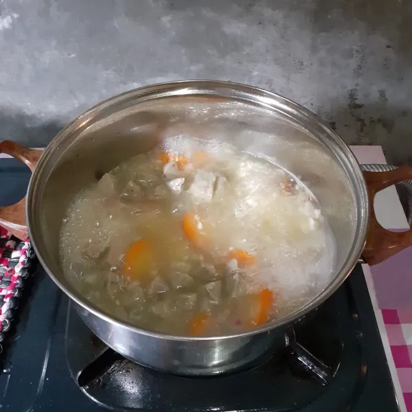 Didihkan air. Masukkan bumbu halus, jahe, wortel, kentang dan bakso. Tambahkan garam dan kaldu bubuk. Masak 4 menit.
