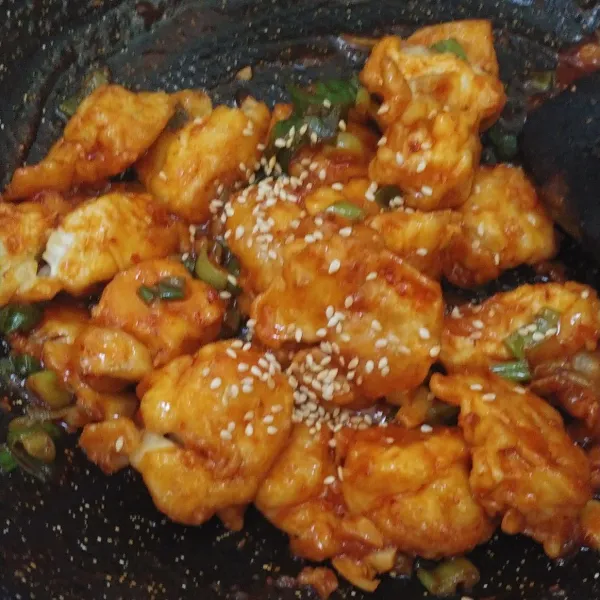 Masukkan tahu yang sudah di goreng dan aduk hingga rata. Sajikan diatas piring dan beri taburan wijen yang telah disangrai.