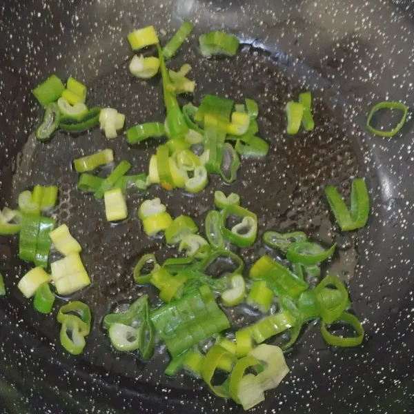 Tumis daun bawang hingga layu. Masukkan bawang putih sambil diaduk