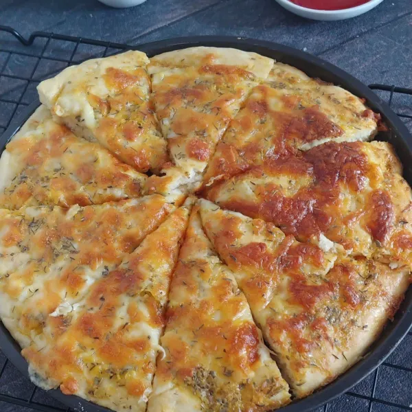 keluarkan pizza dari oven dan iris sesuai selera