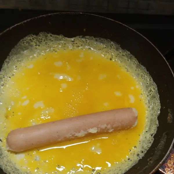 Buat dadar tipis kemudian masukkan sosis lalu gulung