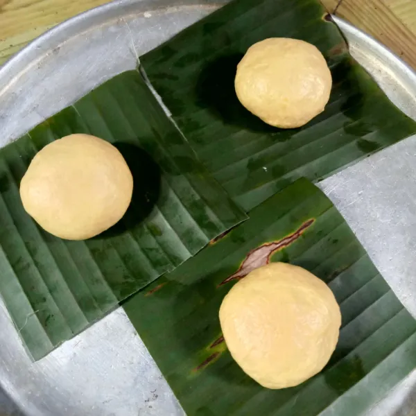 Bagi adonan jadi 12 buah, isi adonan dengan meses dan bentuk bulat, letakkan diatas daun pisang atau baking paper. Lalu tutup dan diamkan lagi sekitar 20 menit.