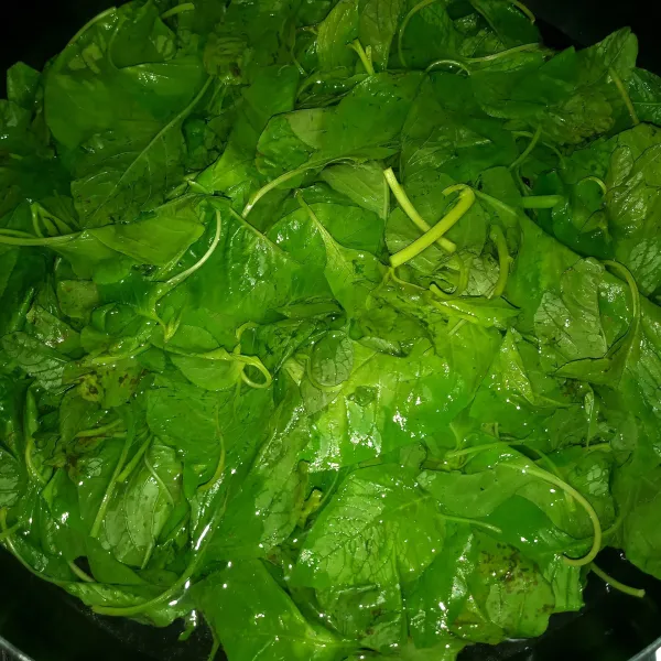 Didihkan air, beri sedikit garam, masukkan bayam dan rebus sampai setengah matang kehijauan.